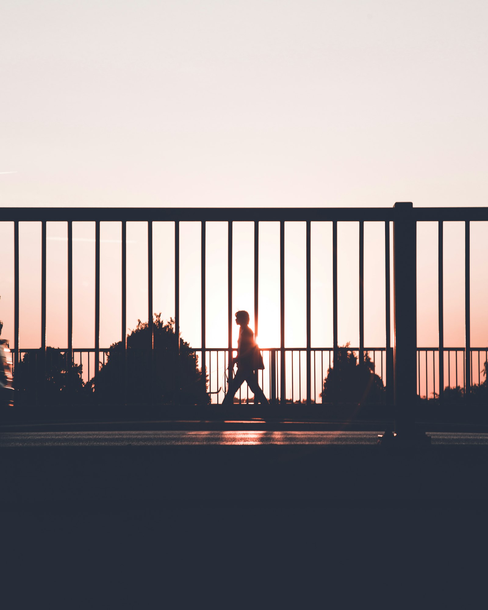 A silhouette walking along a sunset street