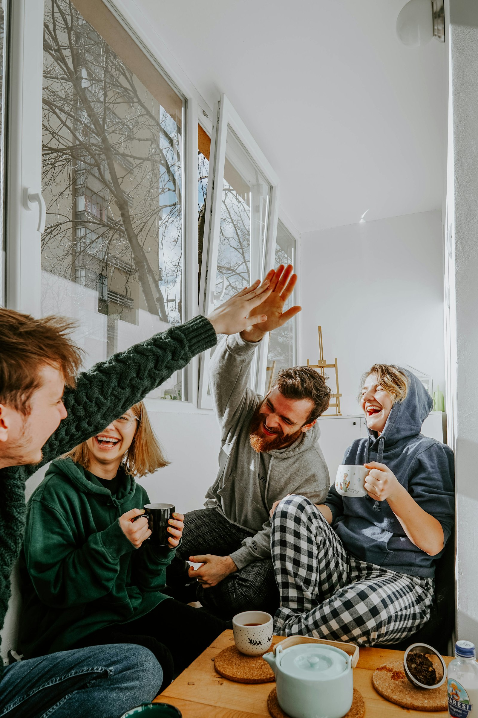 Friends laughing together over tea